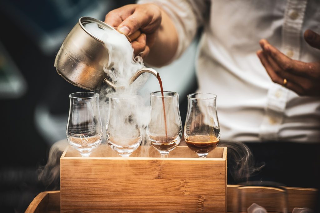 Barista eines Cafes setzt Expressos auf