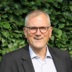 Portrait of Dirk Schmülgen with plants in the background
